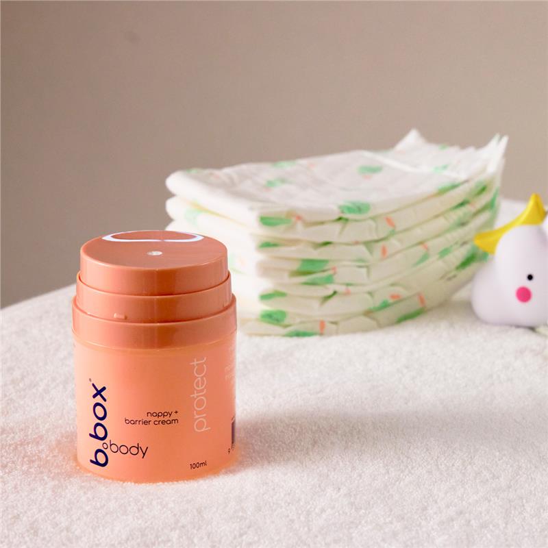 The Protect Nappy and Barrier Cream (100ml) with napkins on the bed.