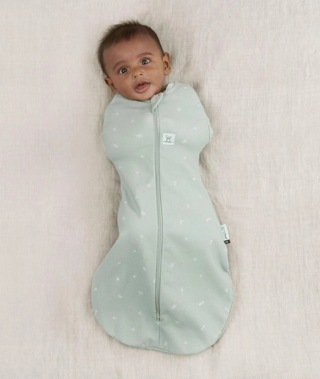 A baby in a Cocoon Swaddle Bag Sage (3-6m)