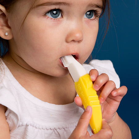 A cute toddler using Baby Banana Toddler Toothbrush