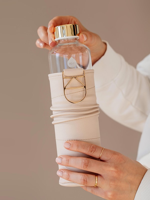 Woman opening a Beige Glass Bottle - Equa