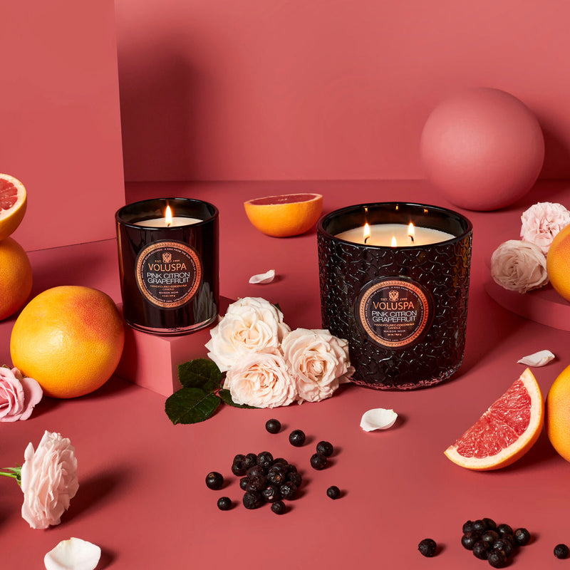 Beautiful Pink Citron Grapefruit Classic Candle with oranges, berries and flowers in a pink background