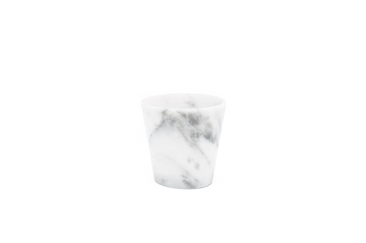 A single Grappa Glass in White Carrara Marble Satin in white background.