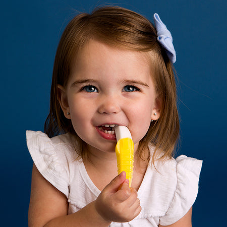A cute toddler using Baby Banana Toddler Toothbrush